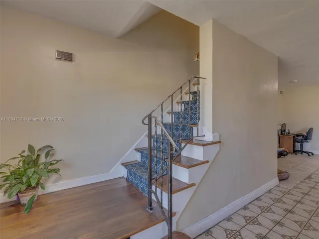 a room with furniture a rug and white walls