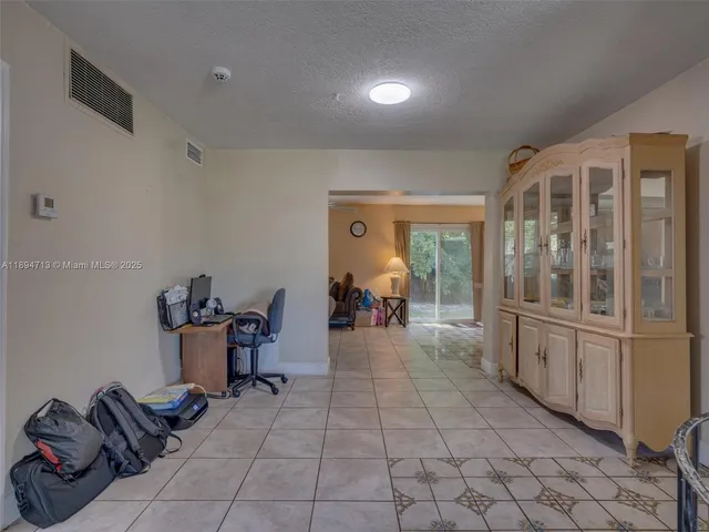 a dining room with furniture and a chandelier fan