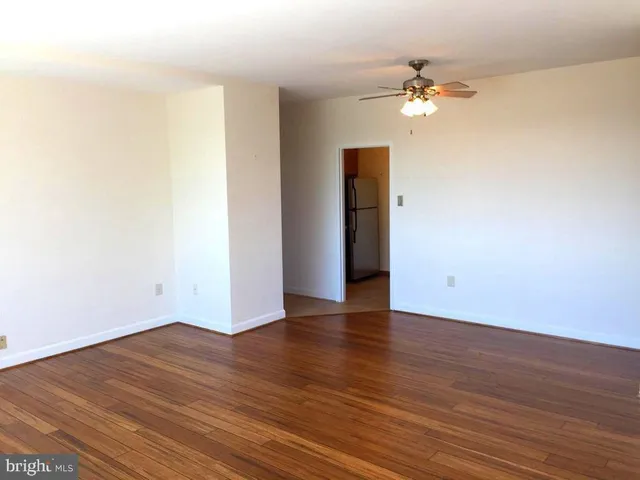 a view of an empty room with wooden floor