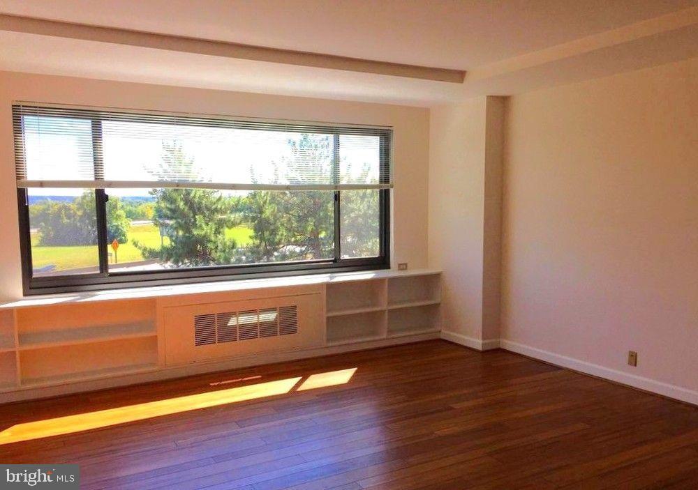 1021 Arlington Boulevard, Unit 330 Arlington, VA 22209 - Photo 10 of 48 a view of an empty room with wooden floor and a window