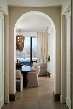 a living room with a table chairs and a large window