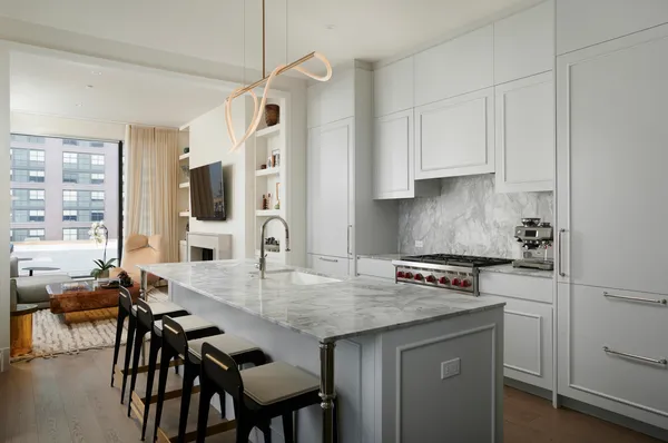a kitchen with granite countertop a table chairs stove and cabinets