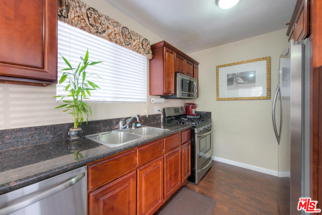 10541 Chandler Boulevard North Hollywood, CA 91601 - Photo 7 of 17 a kitchen with stainless steel appliances granite countertop a sink a refrigerator and a granite counter tops