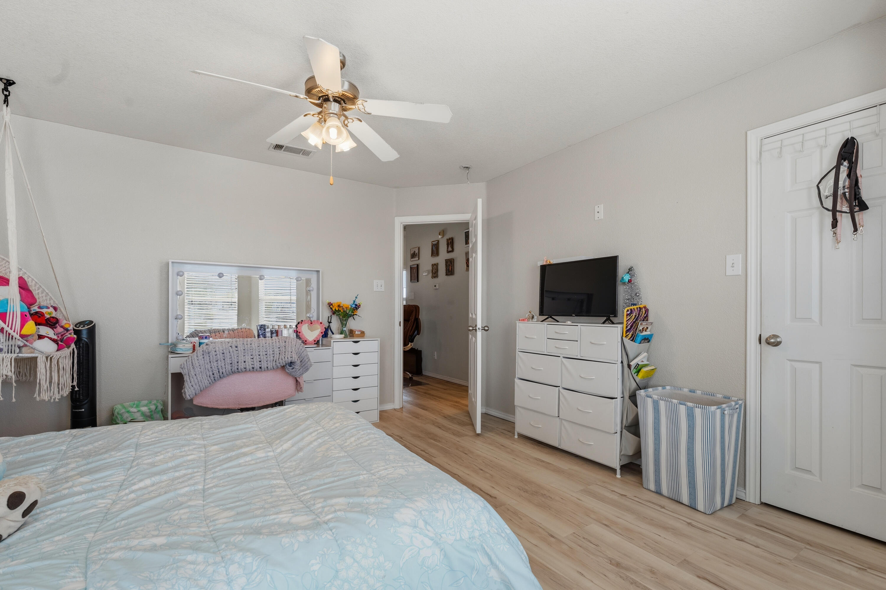 5833 102nd Street Lubbock, TX 79424 - Photo 25 of 36 a bedroom with a bed and a flat tv screen on dresser