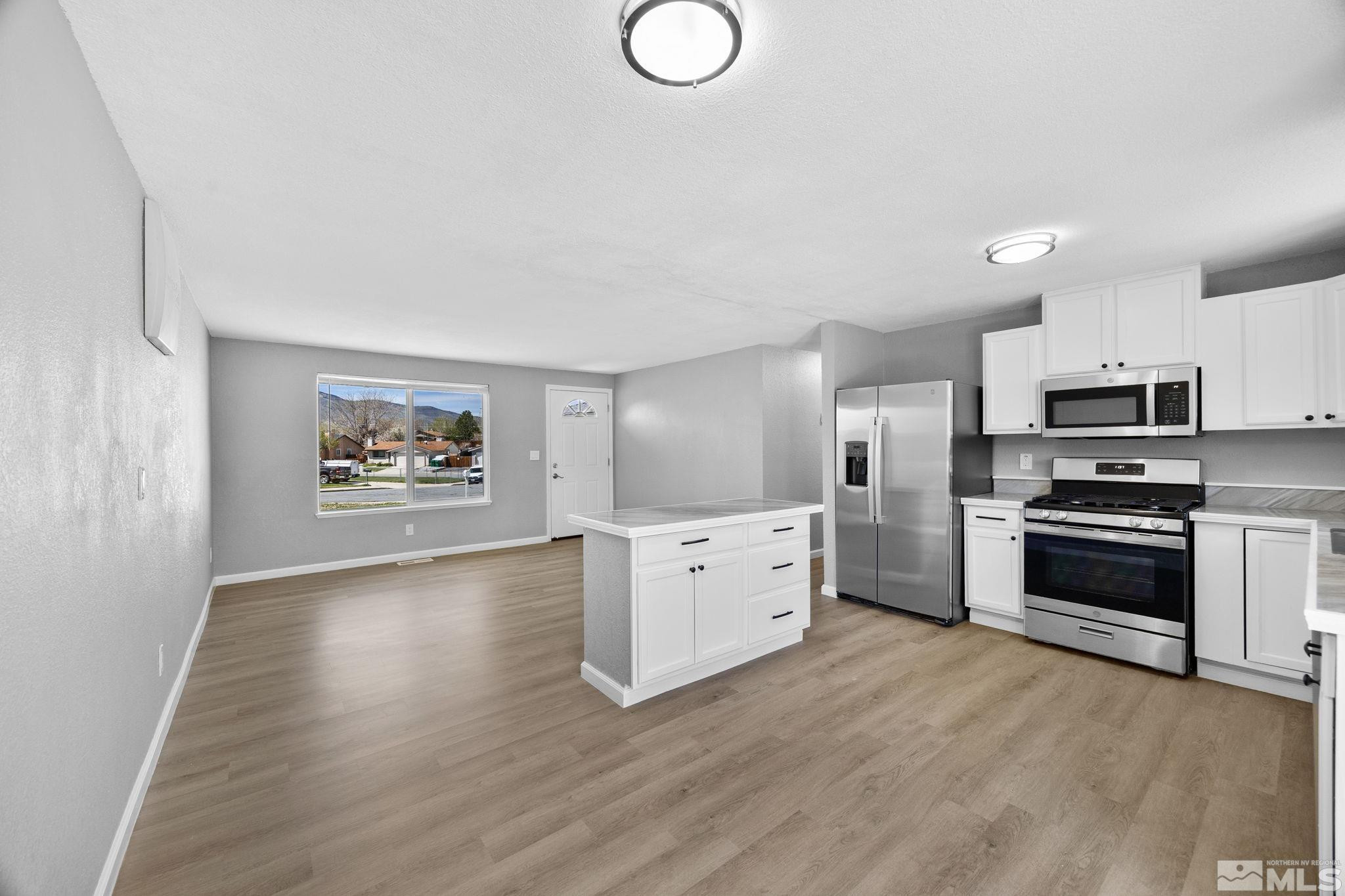 10069 Basalt Court Reno, NV 89506 - Photo 8 of 30 a large kitchen with cabinets wooden floor and stainless steel appliances