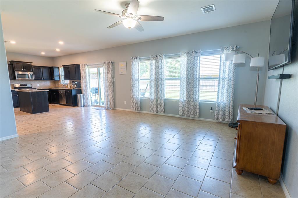 753 Rutherford Drive Crowley, TX 76036 - Photo 5 of 26 Spacious open-concept living area featuring a kitchen with dark cabinetry, stainless steel appliances, and a central island