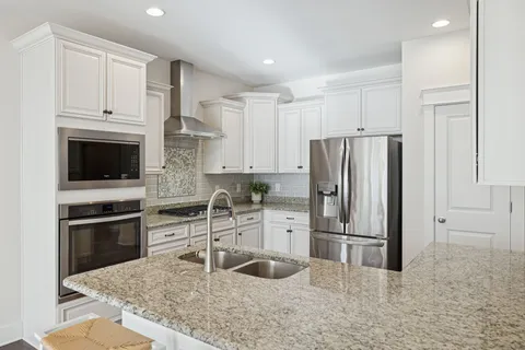 a kitchen with stainless steel appliances granite countertop a refrigerator and a sink