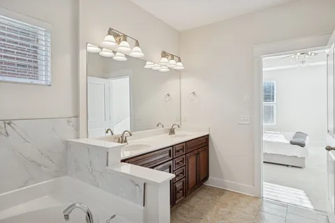 a bathroom with a double vanity sink a mirror and a bathtub