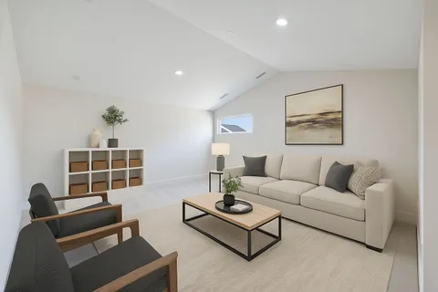 a living room with furniture a window and a flat screen tv