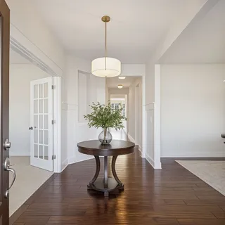 a dining room with wooden floor a glass table and chairs