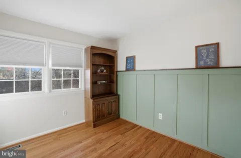a view of an empty room with wooden floor and cabinet