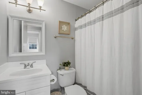 a bathroom with a toilet a sink and a mirror