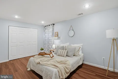 a bedroom with a bed and wooden floor