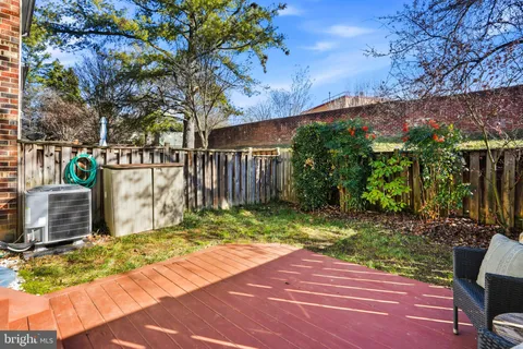 a backyard of a house with table and chairs a barbeque with wooden fence