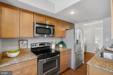 a kitchen with stainless steel appliances granite countertop a stove a refrigerator and a sink