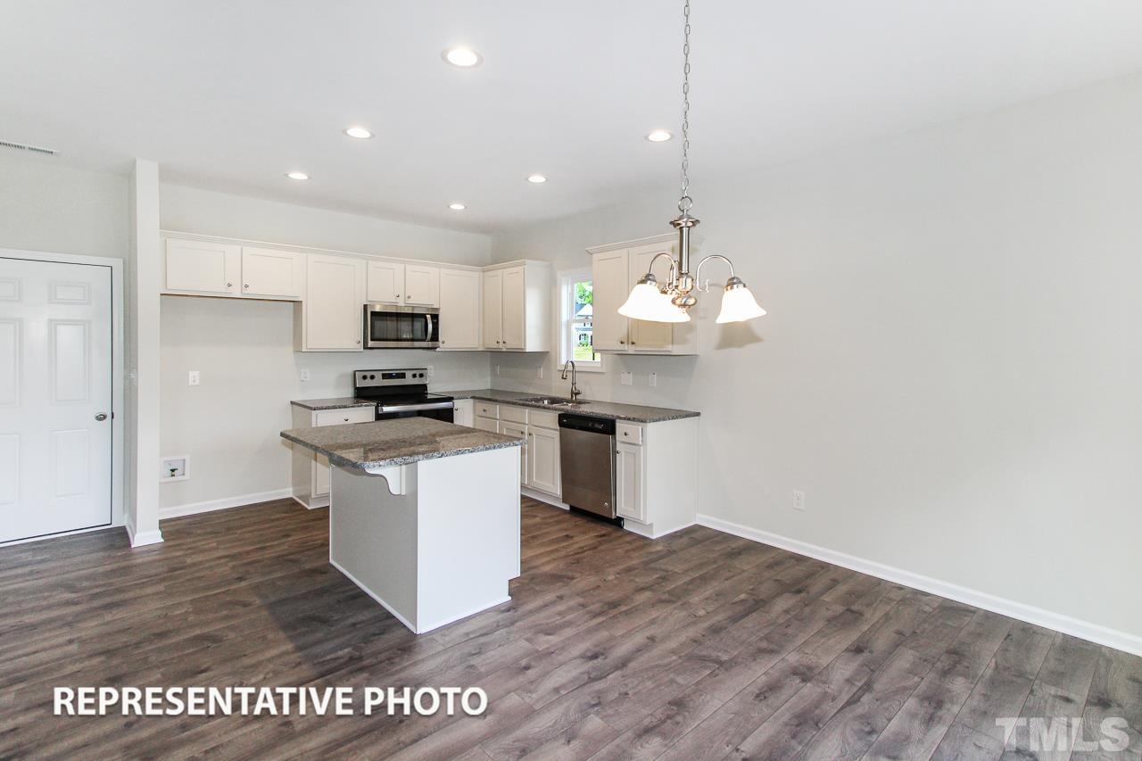 67 Weathervane Dr. Zebulon, NC 27597 - Photo 3 of 10 a kitchen with granite countertop a stove a sink and a refrigerator