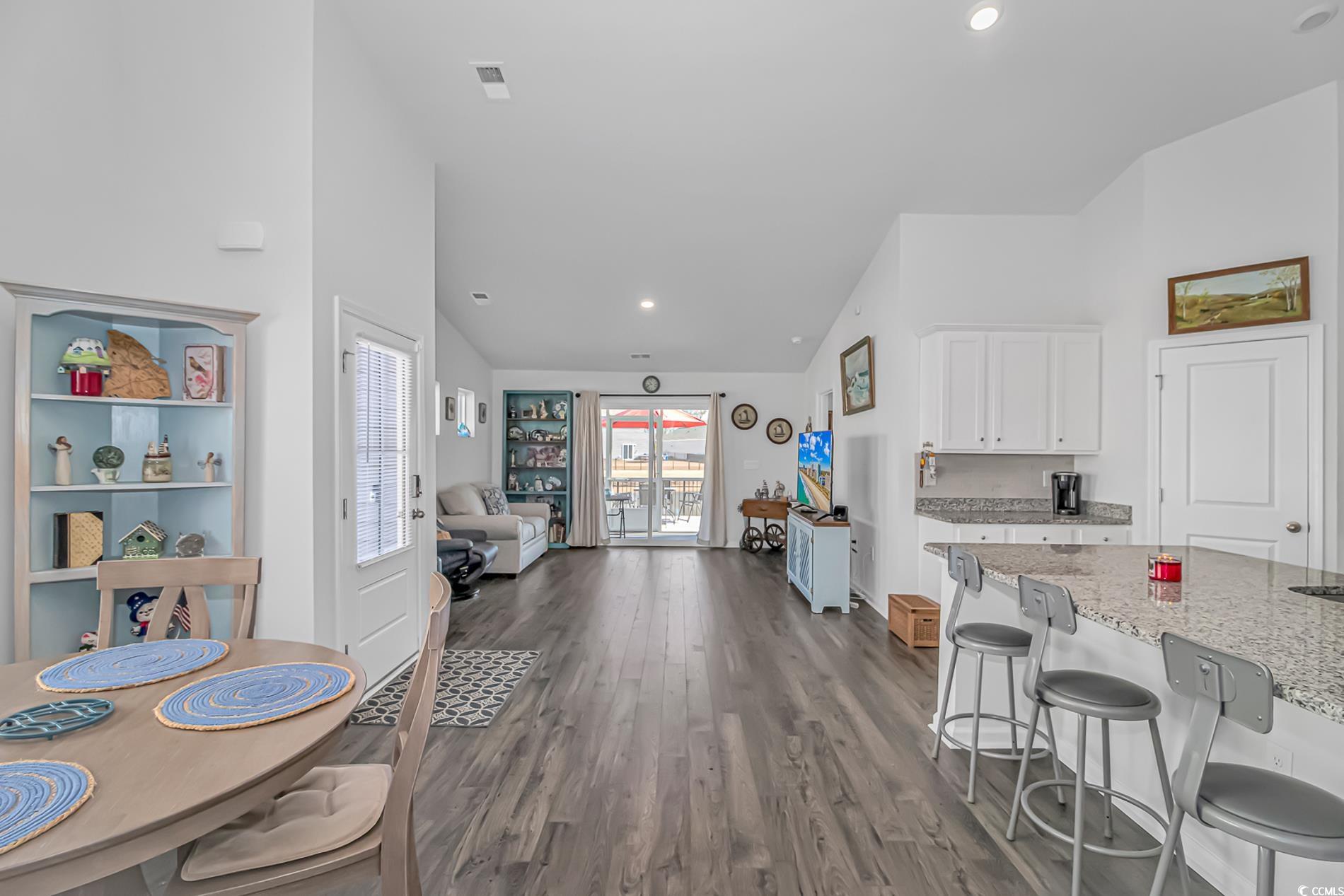 559 Courtridge Loop Conway, SC 29526 - Photo 7 of 37 Kitchen with lofted ceiling, a breakfast bar, white cabinetry, dark hardwood / wood-style floors, and light stone counters