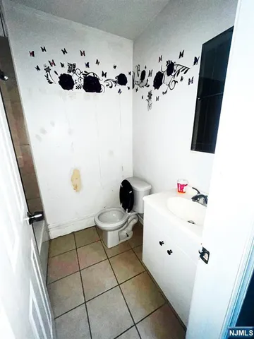 a white toilet sitting next to a white sink and vanity