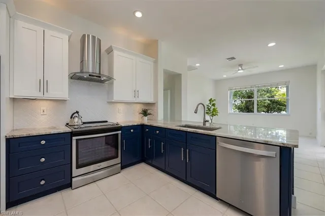 a kitchen with stainless steel appliances granite countertop a sink and cabinets with wooden floor