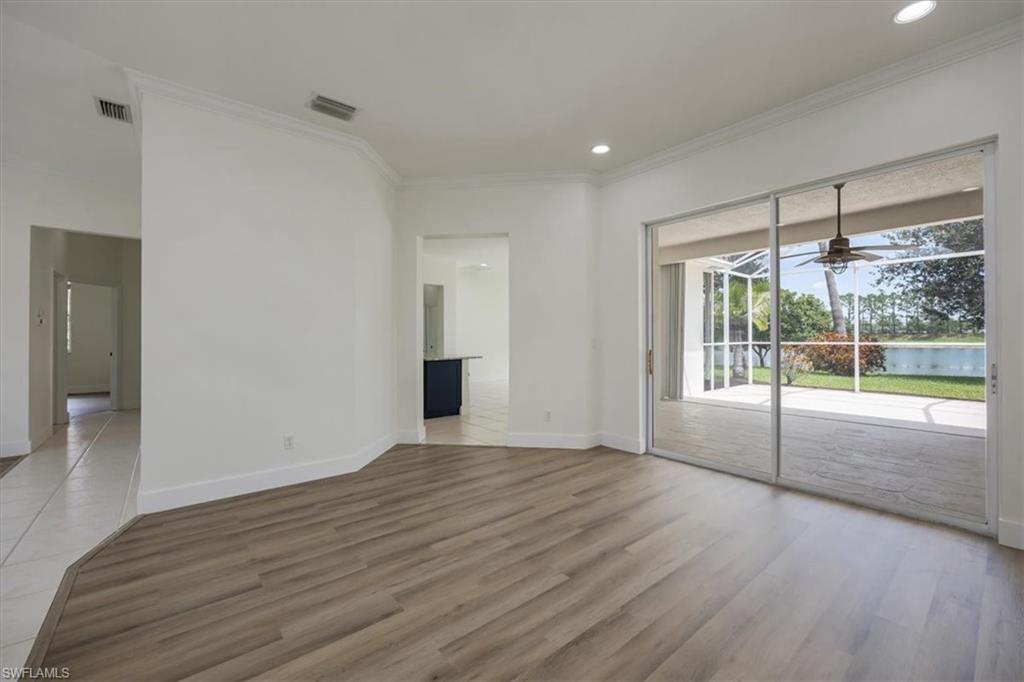 1087 Port Orange Way Naples, FL 34120 - Photo 13 of 50 a view of an empty room with wooden floor and a window