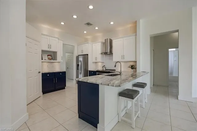 a kitchen with stainless steel appliances granite countertop a refrigerator and a sink