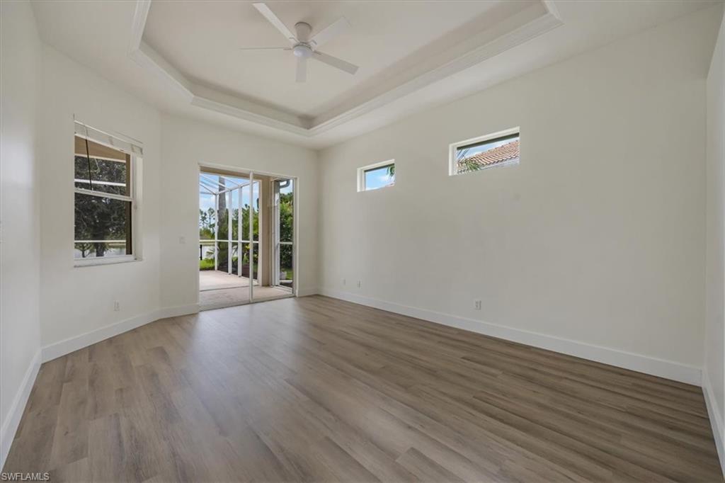 1087 Port Orange Way Naples, FL 34120 - Photo 19 of 50 a view of an empty room with wooden floor and a window