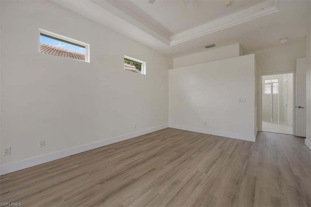 1087 Port Orange Way Naples, FL 34120 - Photo 20 of 50 a view of an empty room with wooden floor and a window