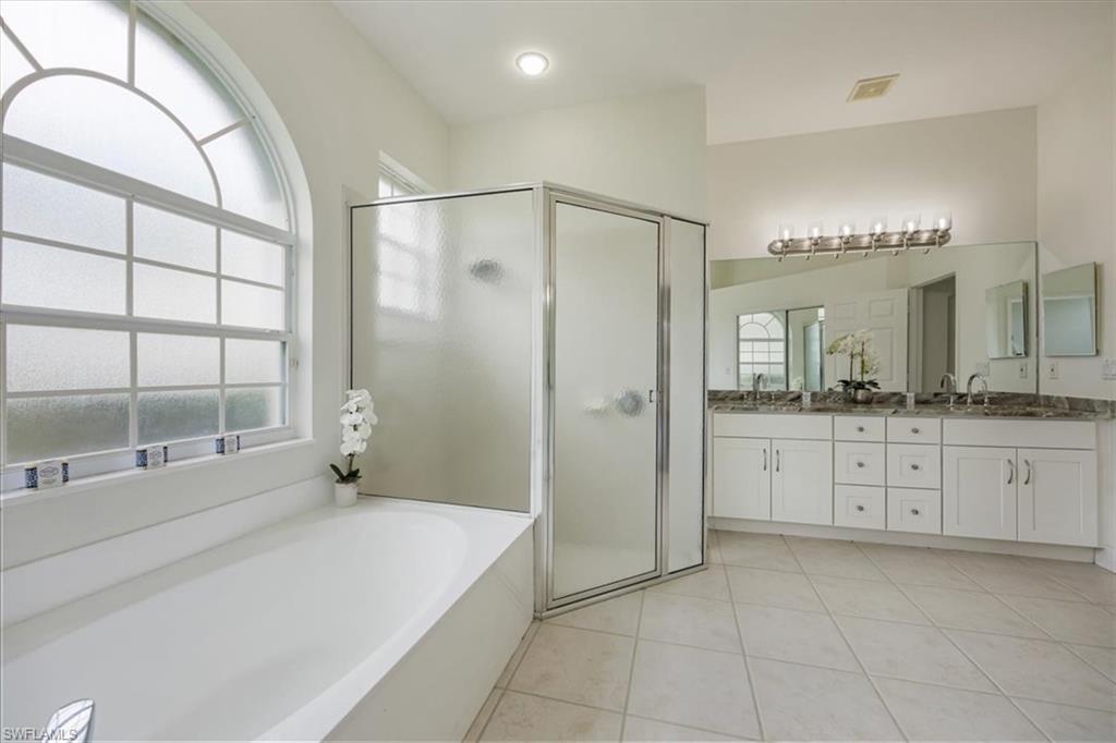 1087 Port Orange Way Naples, FL 34120 - Photo 23 of 50 a spacious bathroom with a shower a sink and a mirror