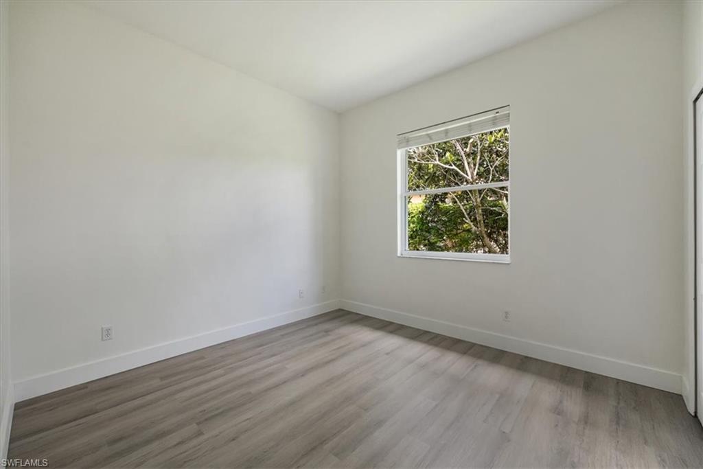 1087 Port Orange Way Naples, FL 34120 - Photo 27 of 50 an empty room with wooden floor and windows