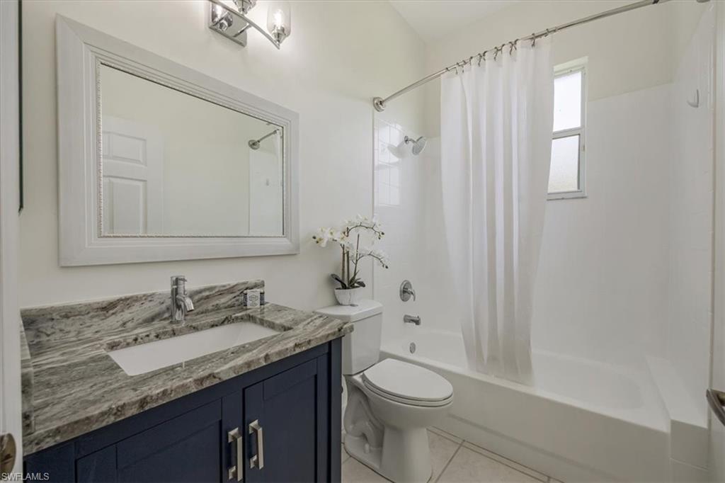 1087 Port Orange Way Naples, FL 34120 - Photo 30 of 50 a bathroom with a granite countertop sink toilet and shower
