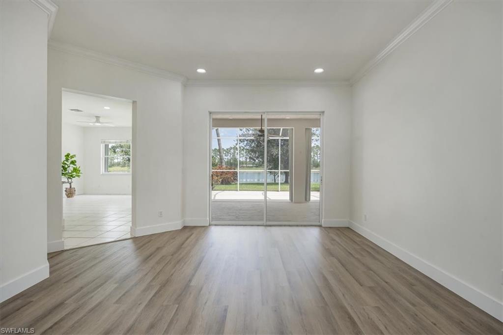 1087 Port Orange Way Naples, FL 34120 - Photo 10 of 50 Living room with extended lanai in background and doorway to kitchen and family room