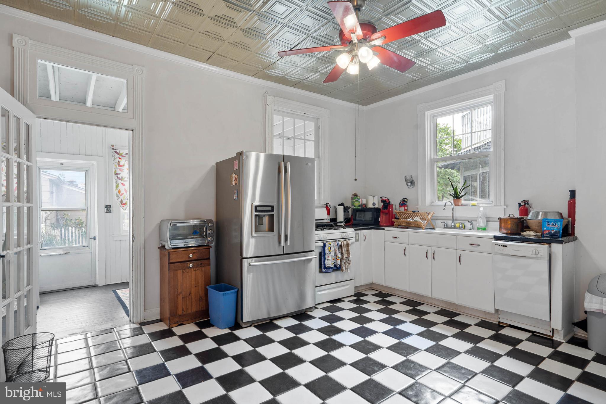 407 Savannah Road Lewes, DE 19958 - Photo 9 of 28 a kitchen with a checkered floor and white stainless steel appliances