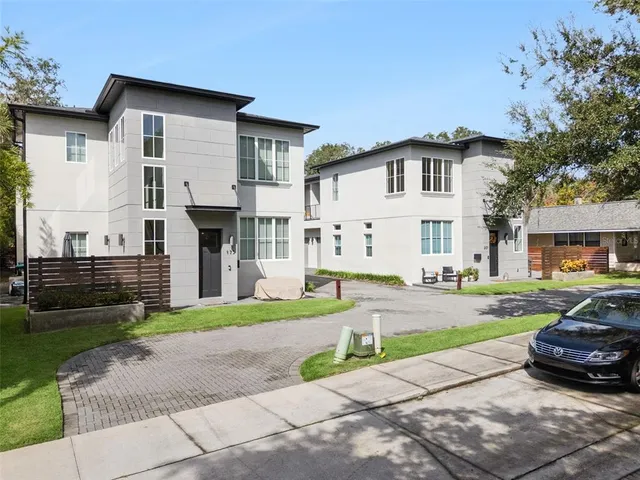 a view of a white house and a yard in front of it