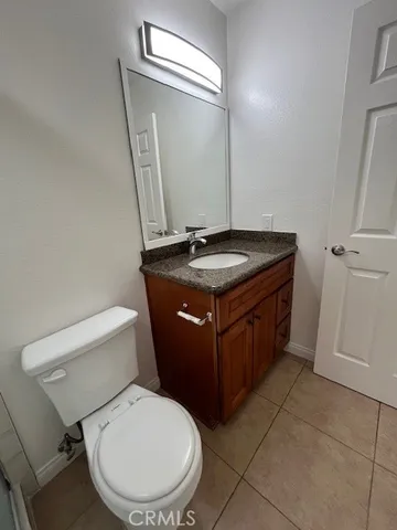 a bathroom with a granite countertop toilet sink and mirror