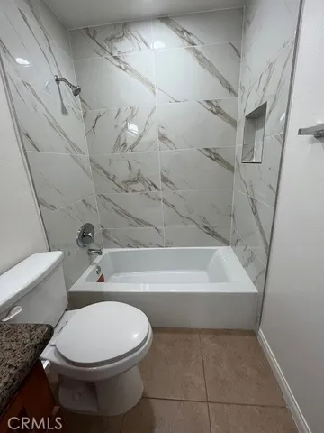 a bathroom with a granite countertop toilet a sink and bathtub