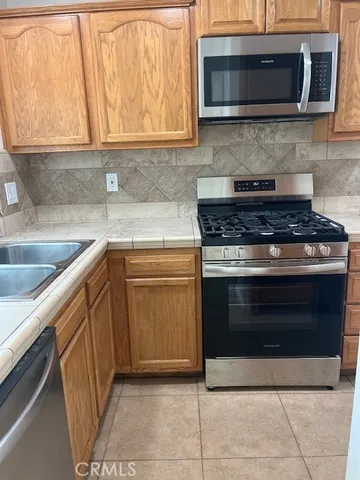 a kitchen with stainless steel appliances granite countertop a stove microwave and sink