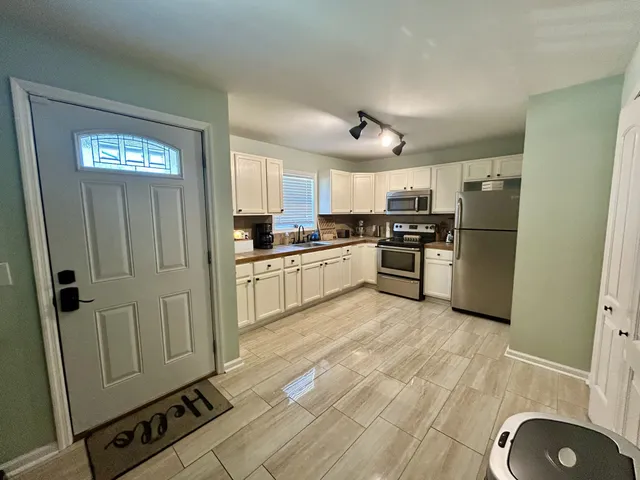 a kitchen with cabinets and wooden floor