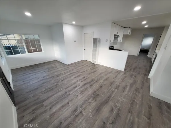 a view of a kitchen with wooden floor and a window