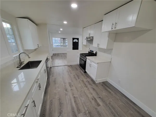 a kitchen with cabinets a sink and wooden floor