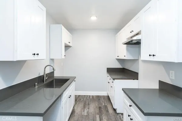 a kitchen with a sink a stove and cabinets