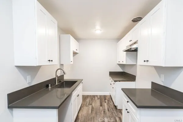 a kitchen with a sink a stove and cabinets