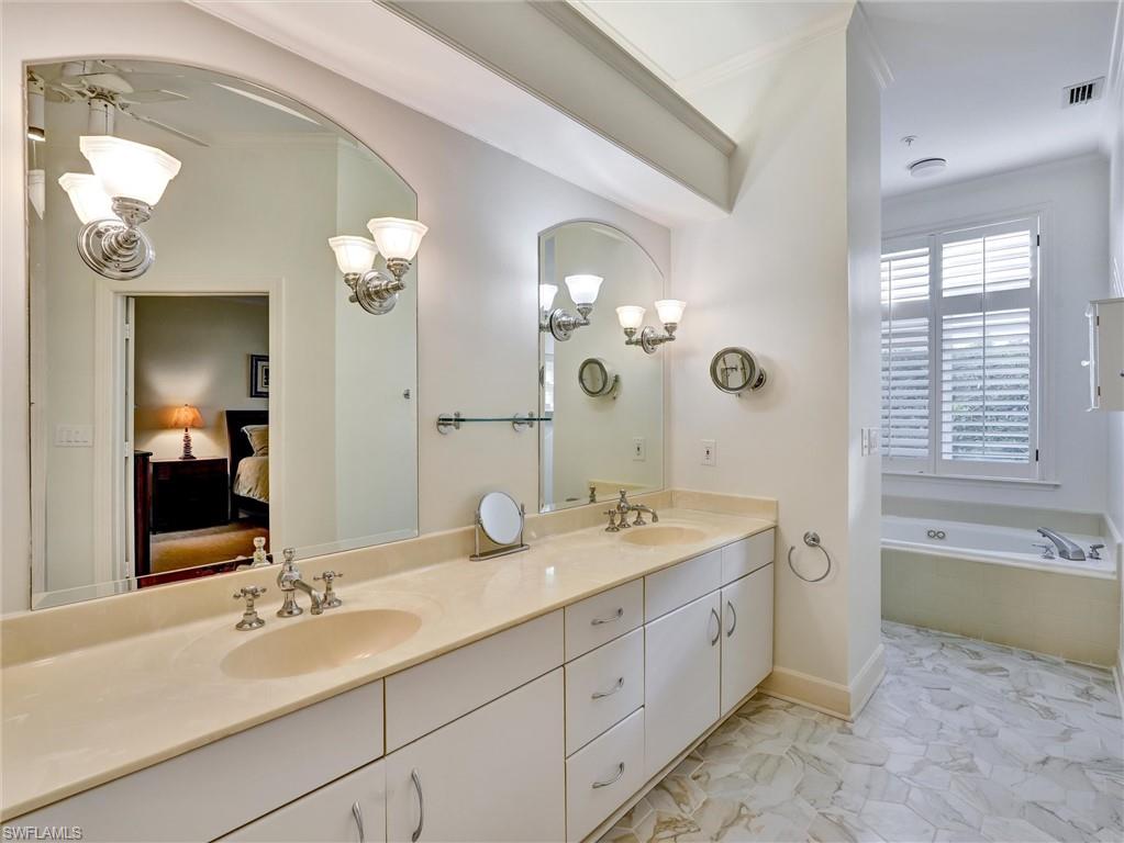 210 2nd Street South, Unit 1C Naples, FL 34102 - Photo 14 of 28 a spacious bathroom with double sink a large mirror and a bathtub