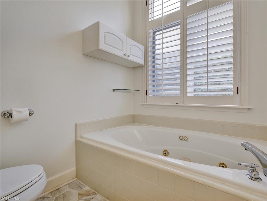 210 2nd Street South, Unit 1C Naples, FL 34102 - Photo 16 of 28 a bathroom with a bathtub and a window