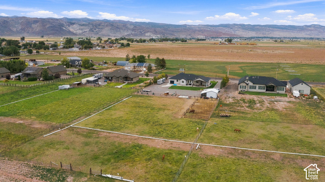 244 East Sevier River Road Central Valley, UT 84754 - Photo 9 of 66 Expansive property with multiple structures, large fenced green spaces, and mountain terrain in the background