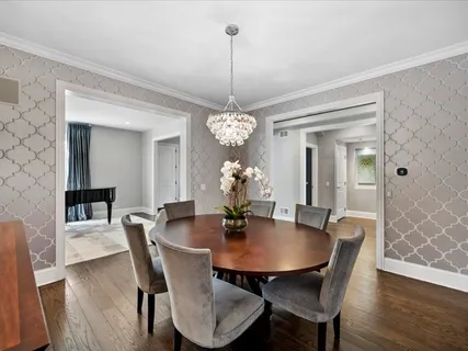 a dining room with furniture wooden floor a chandelier and a rug