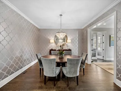 a dining room with furniture a chandelier and wooden floor