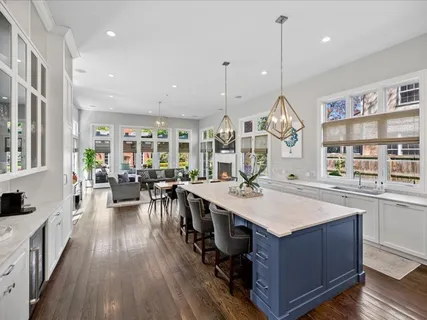 a very nice looking kitchen with a large center island wooden floor and stainless steel appliances