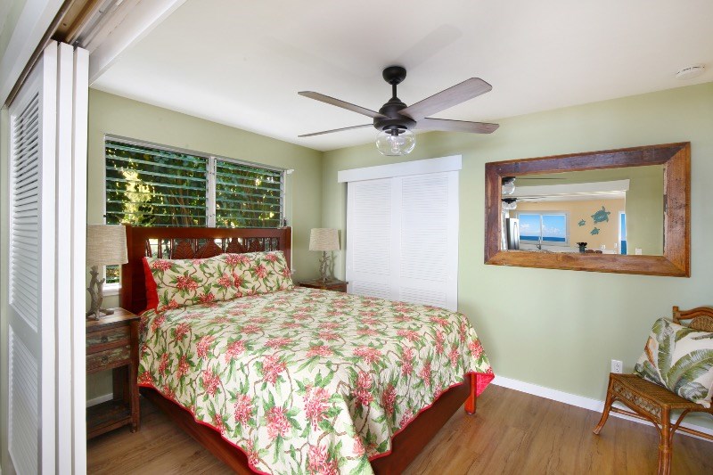 1697 Pe'e Road, Unit 104 Koloa, HI 96756 - Photo 8 of 17 a bedroom with a bed and a painting on the wall