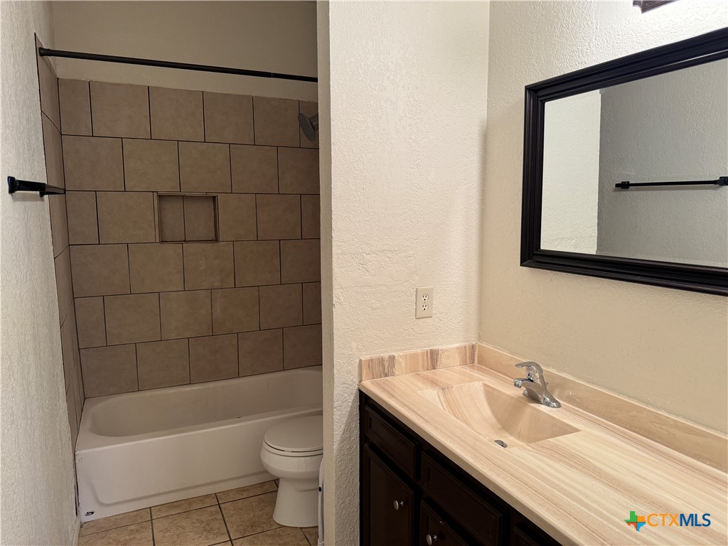 1013 Chestnut Street, Unit D6 San Marcos, TX 78666 - Photo 11 of 13 a bathroom with a granite countertop sink a toilet and bathtub