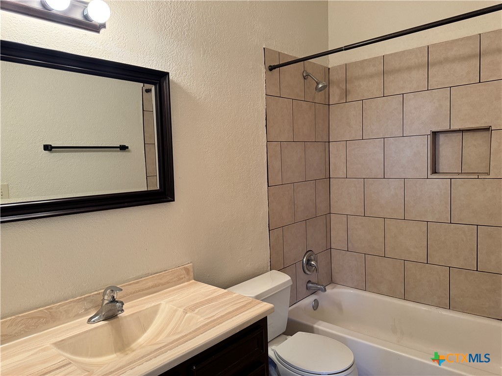 1013 Chestnut Street, Unit D6 San Marcos, TX 78666 - Photo 9 of 13 a bathroom with a granite countertop sink and a mirror